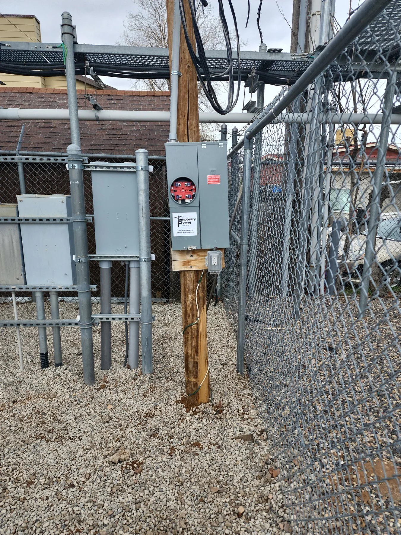 TCS temporary power equipment installed beside a fenced commercial work area